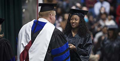 Woman getting her diploma at graduation