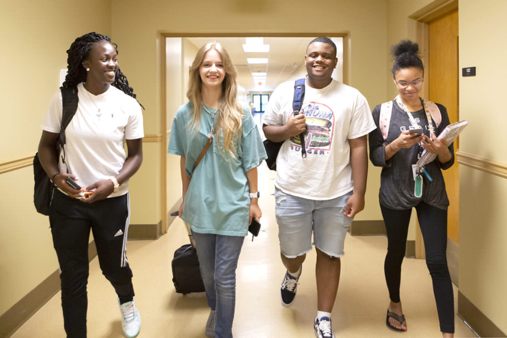 happy students walking down a hallway